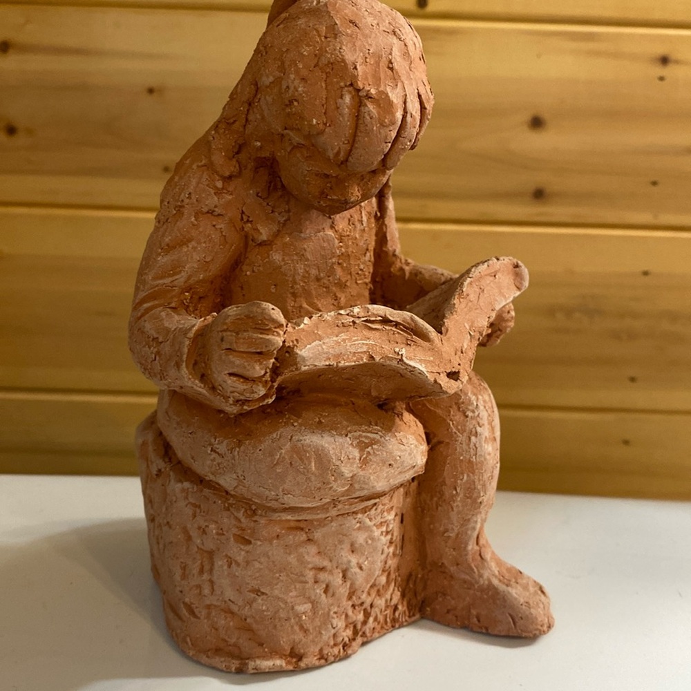 Local artist clay girl reading.